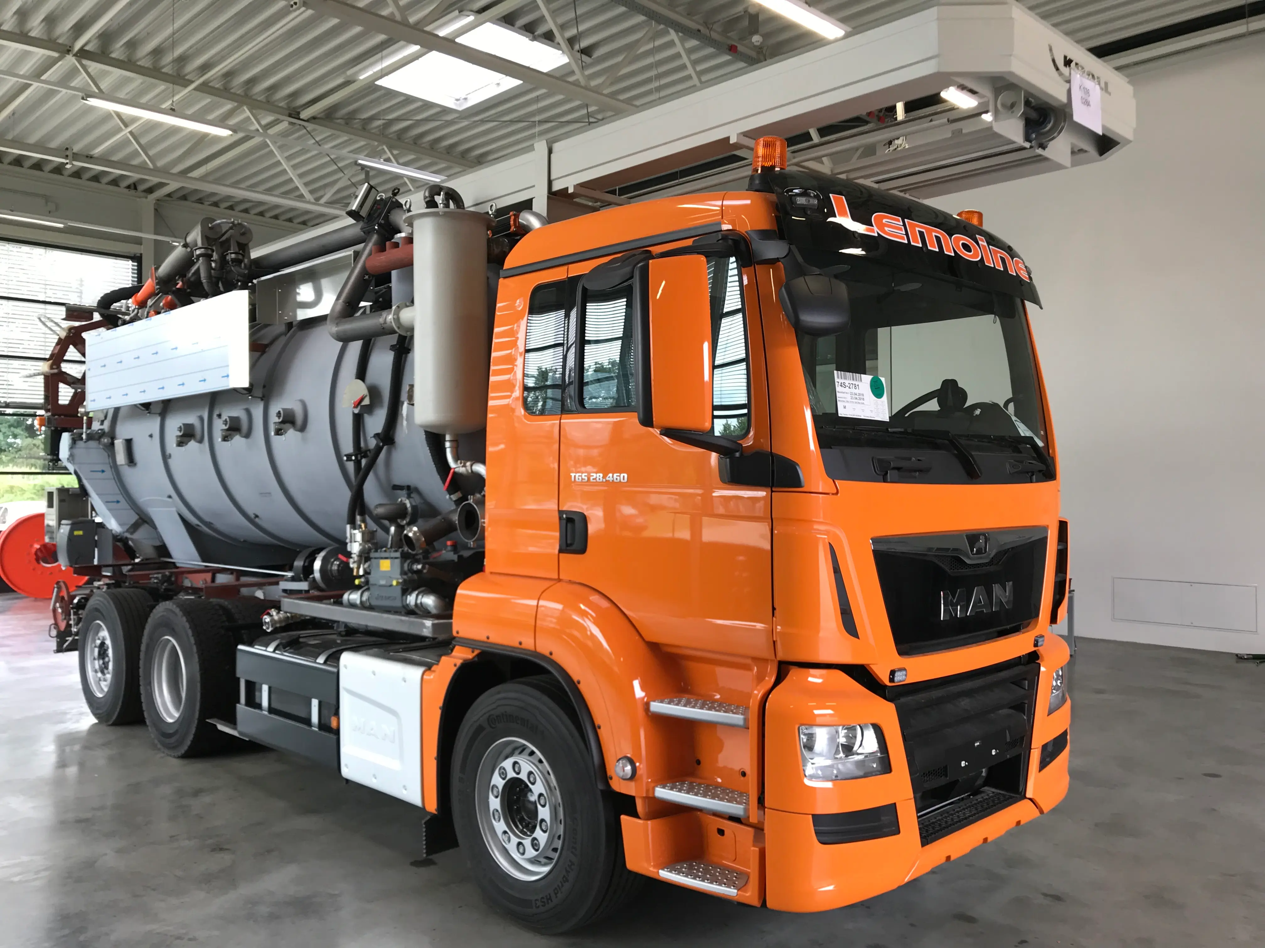 Fertig aufgebauter oranger MAN TGS Saugwagen mit Lemoine-Schriftzug in der Halle